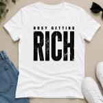 White Busy Getting Rich tee flat lay with jeans and sneakers - hustle tee Toronto