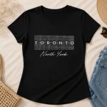 Black Toronto North York fitted tee flat lay - houndstooth lettering pressed in North York