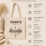 toronto-summer-2026-tote-bag-mockup-03 CN Tower line art canvas tote close-up - Toronto souvenir bag - care instructions