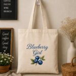 Blueberry Girl canvas tote bag hanging on a hook - cottagecore blueberry print - PrintMyVibe Toronto