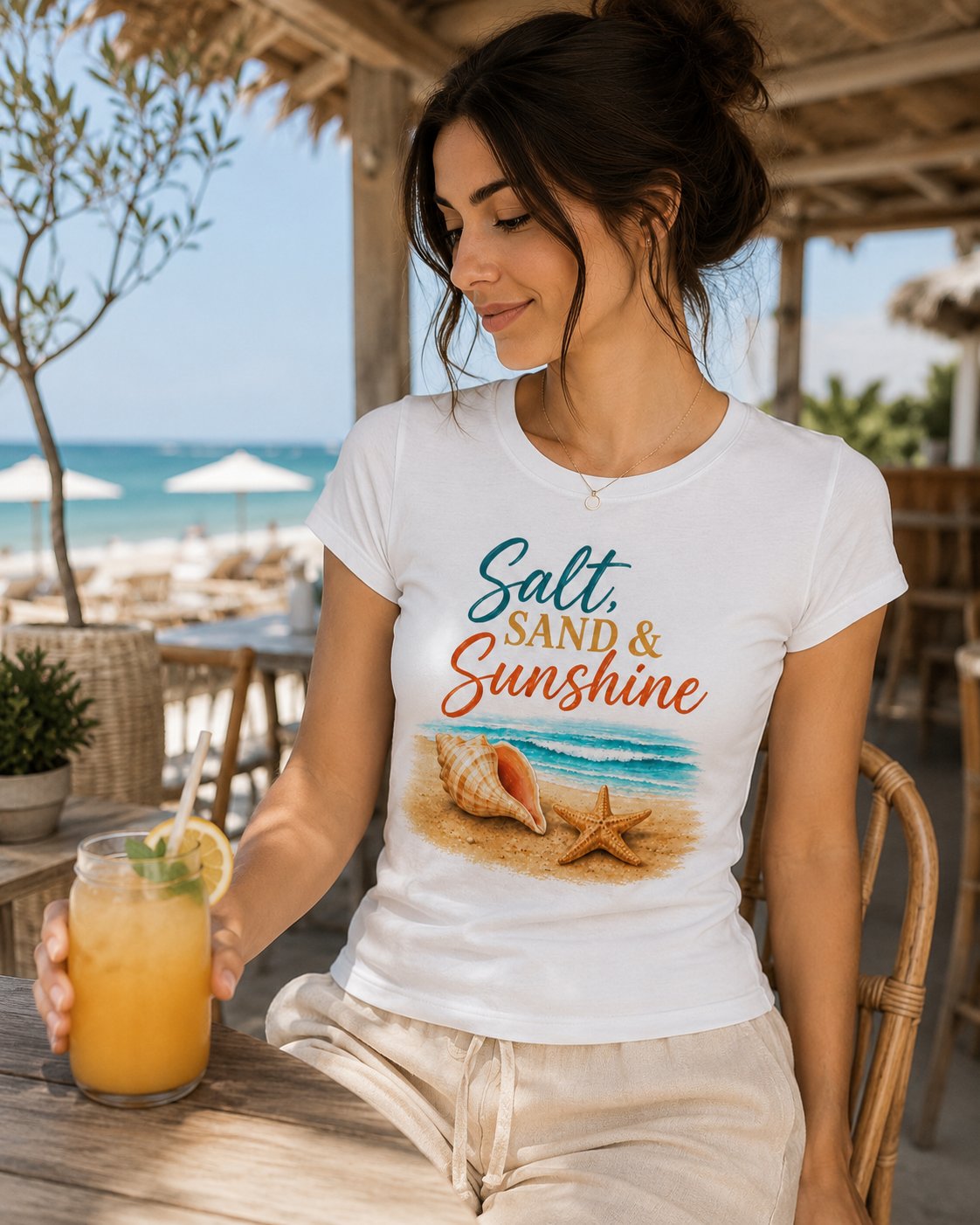 salt-sand-and-sunshine-top-model-drink Woman in the Salt Sand & Sunshine beach tee at a seaside bar with a cold drink