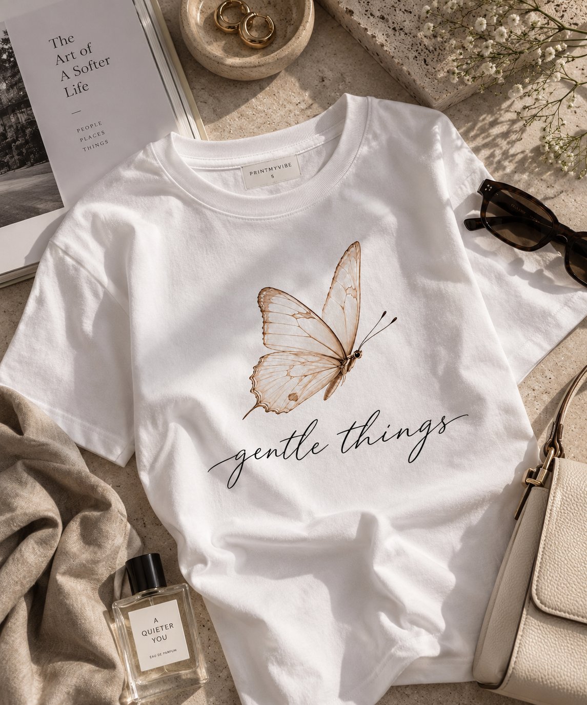 Gentle Things butterfly t-shirt styled flat with books and perfume - aesthetic white tee