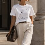 Letting Go dandelion t-shirt worn with cream trousers on a city street - minimalist white tee Toronto