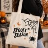Woman carrying the Spooky Season Halloween canvas tote - cobweb and spider design - PrintMyVibe Toronto