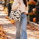 Woman carrying the Bat tote bag down an autumn street - large Halloween canvas tote - PrintMyVibe Toronto
