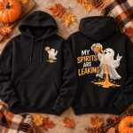 Black My Spirits Are Leaking hoodie flat lay with pumpkins and autumn leaves - front and back