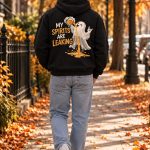 Black ghost beer hoodie worn walking down an autumn street - back print Halloween hoodie Toronto